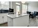 Kitchen island with a granite countertop, stainless steel appliances, and an adjacent dining area at 7621 Avalon Blvd, Fairburn, GA 30213