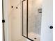 Modern walk-in shower with black trim, marble tile, and a recessed shelf at 7621 Avalon Blvd, Fairburn, GA 30213