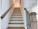 Elegant staircase featuring hardwood steps, white risers, and a stained wood handrail at 7621 Avalon Blvd, Fairburn, GA 30213