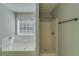 Bathroom featuring a garden tub, tiled walls, and a glass-enclosed shower at 981 Charles Hall Dr, Dacula, GA 30019