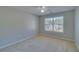 Neutral bedroom with a ceiling fan and a window with a view of greenery at 981 Charles Hall Dr, Dacula, GA 30019