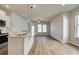 Open-concept living area with hardwood floors, a ceiling fan, and abundant natural light at 288 Abbotts Crossing Cir, Conyers, GA 30094