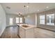 Open-concept living space with large windows offering plenty of natural light and an island sink at 288 Abbotts Crossing Cir, Conyers, GA 30094