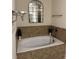 Relaxing soaking tub with tile surround, providing a luxurious spa-like experience at 4858 Stratford Ln, Johns Creek, GA 30022