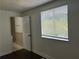 A bedroom features a window, and open door to the bathroom showcasing neutral tile at 1185 Jocelyn Ct, Stone Mountain, GA 30088