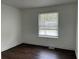 A bright bedroom featuring a dark wood floor and large window providing natural light at 1185 Jocelyn Ct, Stone Mountain, GA 30088