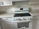 New white electric range oven and stone countertops are featured in this bright kitchen at 1185 Jocelyn Ct, Stone Mountain, GA 30088