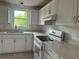 Bright kitchen featuring white cabinetry, new appliances, and stone countertops at 1185 Jocelyn Ct, Stone Mountain, GA 30088