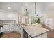 Bright kitchen featuring granite counters, white cabinets, and a view of the adjacent living space at 200 River Vista Dr # 540, Atlanta, GA 30339