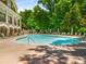 A large community swimming pool with lounge chairs and lush landscaping with waterfalls and a rock feature at 200 River Vista Dr # 540, Atlanta, GA 30339