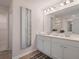 Bright bathroom featuring double sinks, white cabinetry, and a modern accent piece on the wall at 290 Abbotts Crossing Cir, Conyers, GA 30094