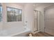 Serene bathroom with a large window overlooking the trees, a soaking tub, and glass enclosed shower at 290 Abbotts Crossing Cir, Conyers, GA 30094