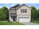 Charming new construction home featuring brick facade, well-manicured lawn, and attached two car garage at 290 Abbotts Crossing Cir, Conyers, GA 30094