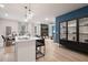 Bright kitchen features an island, stainless appliances, modern lighting, and an adjacent dining and living area at 290 Abbotts Crossing Cir, Conyers, GA 30094