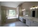 Bathroom featuring double sinks, mirrors, and a large soaking tub at 5029 Preservation Pointe, Kennesaw, GA 30152