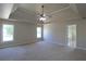 Spacious bedroom featuring a tray ceiling, ceiling fan, and natural lighting at 5029 Preservation Pointe, Kennesaw, GA 30152