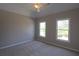 Neutral bedroom featuring a tray ceiling with ceiling fan and two windows at 5029 Preservation Pointe, Kennesaw, GA 30152