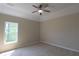 Neutral bedroom with a ceiling fan, tray ceiling, natural light, and neutral carpet at 5029 Preservation Pointe, Kennesaw, GA 30152