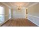 Bright dining room boasts hardwood floors, detailed molding, and a stylish chandelier at 5029 Preservation Pointe, Kennesaw, GA 30152