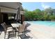 Relaxing pool area features an umbrella-covered table with chairs for outdoor enjoyment at 5029 Preservation Pointe, Kennesaw, GA 30152