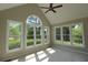 Light-filled sunroom with vaulted ceiling, ceiling fan, and large windows overlooking lush greenery at 5029 Preservation Pointe, Kennesaw, GA 30152