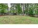 The backyard is fenced and boasts mature trees with a grassy area at 64 Little John Way, Douglasville, GA 30134