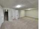 Finished basement with large recreation space with drop ceiling and neutral carpet at 64 Little John Way, Douglasville, GA 30134