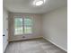 Cozy bedroom with neutral carpeting, a window, and a door at 64 Little John Way, Douglasville, GA 30134