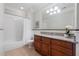 Well-lit bathroom with granite countertops, a wooden vanity, and a shower-tub combo with subway tile surround at 77 Peachtree Ne Pl # 608, Atlanta, GA 30309