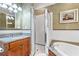 Stylish bathroom featuring a soaking tub with granite counters and a glass-enclosed shower with white subway tile at 77 Peachtree Ne Pl # 608, Atlanta, GA 30309