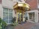 Building entrance featuring gold doors, stone accents, and manicured landscaping; sophisticated and inviting at 77 Peachtree Ne Pl # 608, Atlanta, GA 30309