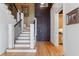 Inviting foyer with gleaming hardwood floors and staircase featuring white posts and iron spindles at 77 Peachtree Ne Pl # 608, Atlanta, GA 30309
