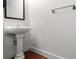 Bathroom featuring a pedestal sink, mirror, and hardwood flooring at 1261 Caroline Street Ne # 206, Atlanta, GA 30307