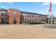 Exterior view of red brick building with green space and American flag at 1261 Caroline Street Ne # 206, Atlanta, GA 30307