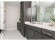 Modern bathroom featuring sleek gray cabinetry, double sinks, and a glass-enclosed shower offering style and functionality at 1371 Walking Way, Atlanta, GA 30316