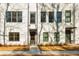 New construction townhome featuring painted brick, gray trim, and landscaped front yard, on a sunny day at 1371 Walking Way, Atlanta, GA 30316