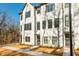 Three-story townhome featuring painted brick, gray trim, and inviting entrance, showcasing modern design at 1371 Walking Way, Atlanta, GA 30316