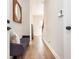Hallway with light wooden floors and a decorative mirror, leading to the front door at 1371 Walking Way, Atlanta, GA 30316