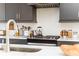 Kitchen with gray cabinets, herringbone backsplash, and stainless steel gas range at 1371 Walking Way, Atlanta, GA 30316