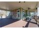 Spacious outdoor patio with a stone accent wall, dining tables, ceiling fans, and wood floors at 235 Laurel Vista Dr, Canton, GA 30114