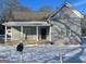 Charming home with a covered porch, complemented by snow-covered yard and a sunny sky at 2391 Randall Ave, Lithonia, GA 30058