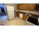 Kitchen features tile floors, oak cabinets and white dishwasher at 2391 Randall Ave, Lithonia, GA 30058