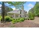Charming home exterior with a stone patio, lush greenery, and elegant architectural details at 295 River Laurel Way, Woodstock, GA 30188