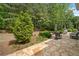 Scenic backyard with a stone patio, lounge chairs, and beautiful landscaping at 295 River Laurel Way, Woodstock, GA 30188