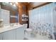 Cozy bathroom features a sink, toilet, vanity, and shower with a floral shower curtain at 295 River Laurel Way, Woodstock, GA 30188