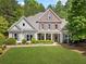 Charming two-story home boasts beautiful landscaping, a brick facade and a welcoming front porch at 295 River Laurel Way, Woodstock, GA 30188