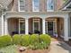Welcoming front porch with brick accents and comfortable seating, surrounded by lush greenery and landscaping at 295 River Laurel Way, Woodstock, GA 30188