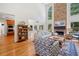 Bright living room featuring hardwood floors, a stone fireplace, and ample natural light at 295 River Laurel Way, Woodstock, GA 30188