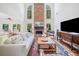 Inviting living room with a stone fireplace, hardwood floors, and large windows offering natural light at 295 River Laurel Way, Woodstock, GA 30188