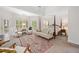 A spacious main bedroom features a sitting area, decorative rug, four poster bed and backyard views at 295 River Laurel Way, Woodstock, GA 30188